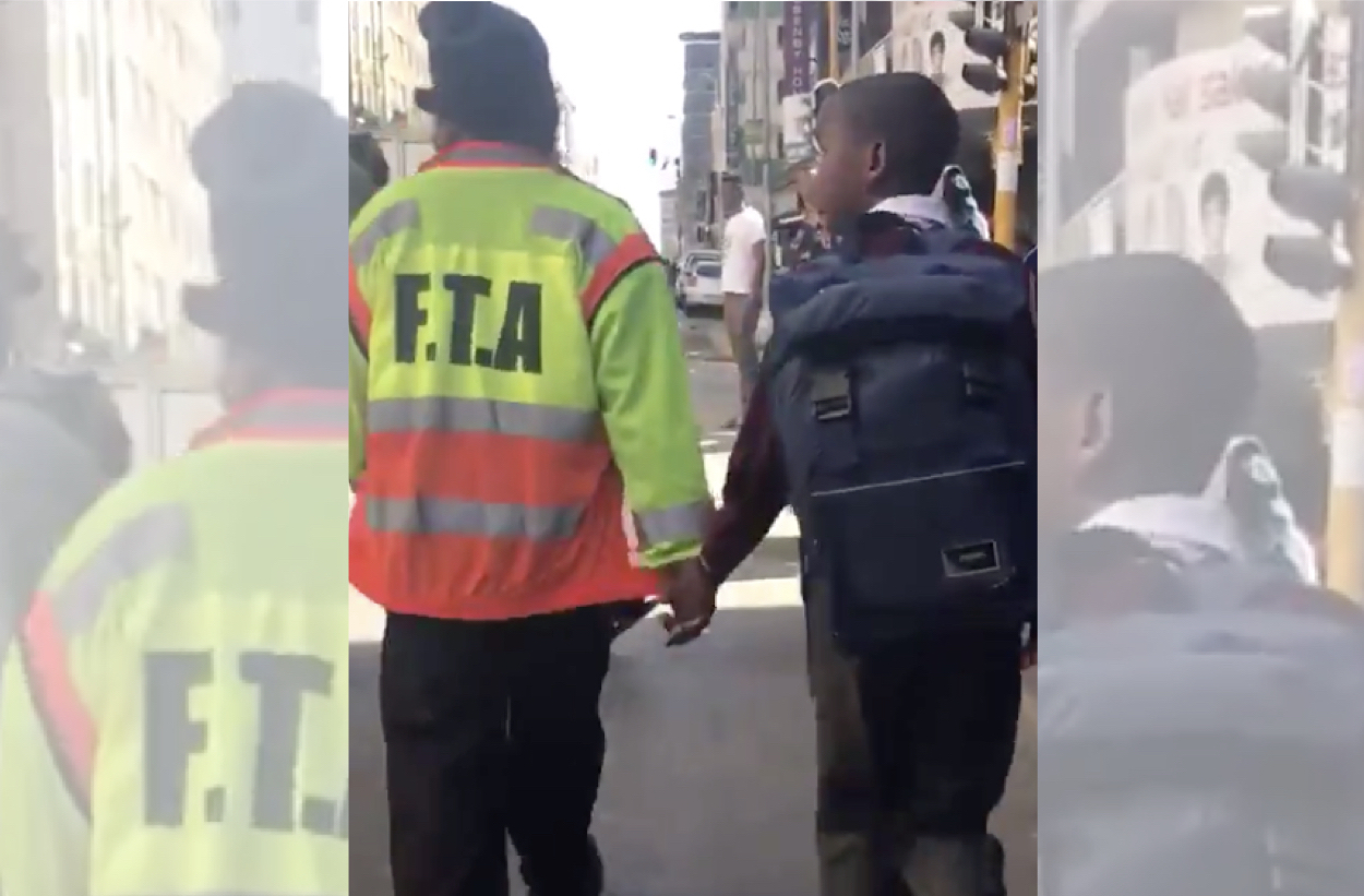 Watch: Taxi Marshal holds young learner's hand to guide him safely away from protests